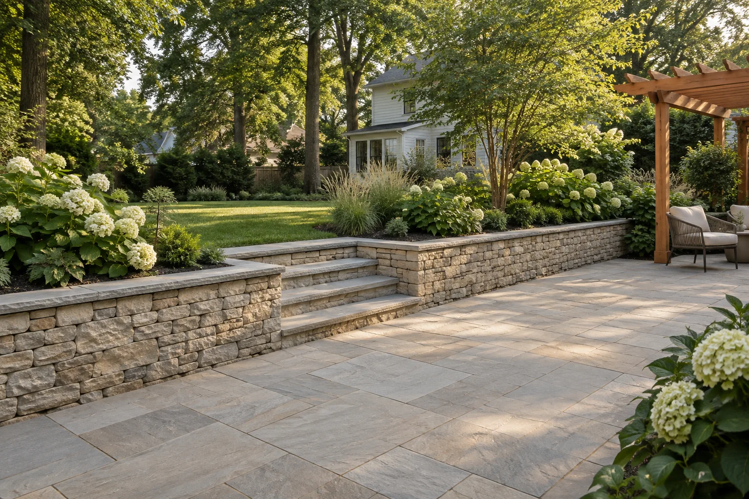 Design concept of a limestone patio, low garden wall and steps into a leafy backyard